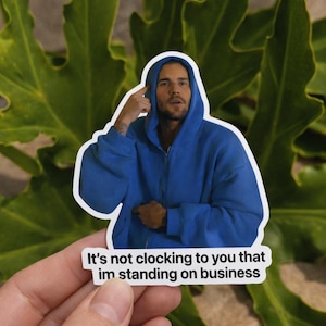 May include: A sticker featuring a person in a blue hooded sweatshirt, pointing to their head. The sticker has the text: "It's not clocking to you that im standing on business."