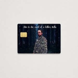 Peut inclure: Une carte de cr&eacute;dit noire avec une puce dor&eacute;e et le texte "this is the card of a killer, Bella". La carte pr&eacute;sente une image d'un homme dans une chemise scintillante debout dans une for&ecirc;t.