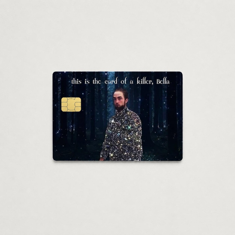 Peut inclure: Une carte de cr&eacute;dit noire avec une puce dor&eacute;e et le texte "this is the card of a killer, Bella". La carte pr&eacute;sente une image d'un homme dans une chemise scintillante debout dans une for&ecirc;t.