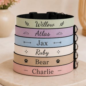 May include: A stack of six personalized pet collars in pastel colors. Each collar is labeled with a pet's name: Willow, Atlas, Jax, Ruby, Bear, and Charlie. The collars have black hardware and are stacked on a round, light-colored surface.