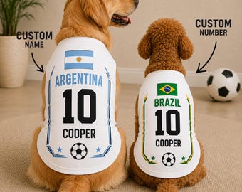 May include: Two white dog jerseys featuring national flags and soccer themes. The left jersey displays the Argentina flag, the text ARGENTINA, the number 10, and the name COOPER. The right jersey shows the Brazil flag, BRAZIL, 10, and COOPER.