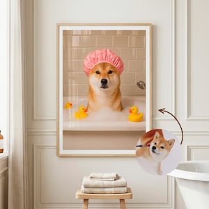 Puede incluir: Una impresi&oacute;n enmarcada muestra un perro Shiba Inu en una ba&ntilde;era, con un gorro de ducha rosa. El perro est&aacute; rodeado de burbujas y patitos de goma amarillos. El ba&ntilde;o tiene baldosas beiges.