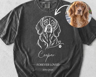 May include: A charcoal gray short-sleeve t-shirt featuring a white line-art illustration of a spaniel dog. Below the dog is the name Cooper, the text FOREVER LOVED, and the years 2010-2024. A circular inset shows a photo of the dog.