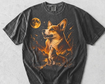 May include: A charcoal gray short-sleeve t-shirt featuring a graphic print of a large Corgi head above a smaller Corgi howling at a glowing orange moon. The design includes orange mountain silhouettes, stars, and a shooting star against a dark sky.