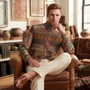 Puede incluir: Una chaqueta de manga larga con un estampado de tapiz floral y geométrico multicolor, cuello mao y cierres de palanca, combinada con pantalones de color crema y mocasines de cuero marrón.