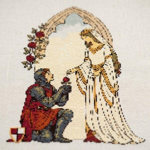 May include: A cross-stitch embroidery featuring a knight in dark blue armor and a red tunic kneeling to offer a red rose to a figure in a long white and gold gown. The scene is framed by a stone archway adorned with red roses and green leaves.