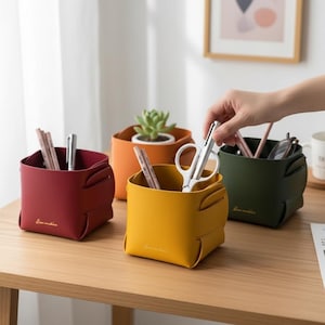 Può includere: Quattro organizzatori da scrivania colorati in rosso, giallo, arancione e verde, ciascuno contenente forniture per ufficio. L'organizzatore giallo contiene forbici. Gli organizzatori rosso, giallo e verde hanno il testo "Love sunshine" sul davanti. Una piccola pianta grassa è nell'organizzatore arancione.