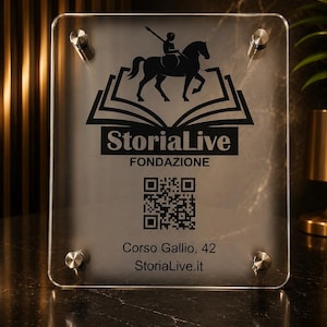 May include: A clear acrylic sign with a silver backing, featuring a black logo of a knight on horseback above the text "StoriaLive Fondazione." Includes a QR code and address details. Secured with four silver standoffs.