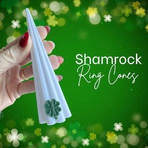 May include: A white, cone-shaped ring holder with a green shamrock accent. The text "Shamrock Ring Cones" is displayed on a green background with shamrock decorations.