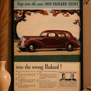 May include: Framed vintage advertisement for the 1938 Packard Eight. The maroon car is the focal point, set against a backdrop of a tree and a light blue sky. The ad includes text and illustrations.