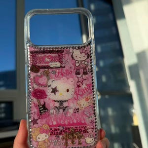 May include: Clear phone case with a pink interior featuring Hello Kitty graphics, stars, and the word "Kitty." The case is embellished with rhinestones around the edges and includes the text "Bubble Planet."