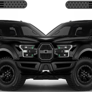 May include: Two matte black rectangular decals featuring a stylized American flag design with horizontal stripes and stars. These adhesive overlays are shown positioned on the front side panels of a black pickup truck, highlighting the placement.