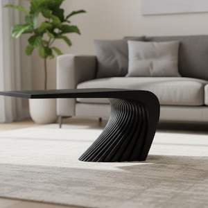 May include: A modern black coffee table with a unique, curved design. The table's base features a series of vertical, wave-like lines, and the top is a flat, rectangular surface. The table is in a living room setting with a gray sofa and a potted plant.