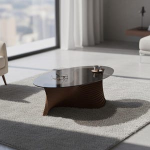 May include: Modern living room with a low, oval coffee table. The table has a dark glass top and a brown, wave-like wooden base. A cup and saucer sit on the table, along with a pair of glasses. The room features a light gray rug and a cream-colored armchair.