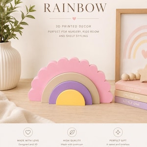 K&ouml;nnte beinhalten: Ein pastellfarbenes, regenbogenf&ouml;rmiges Holzspielzeug in Rosa, Beige, Lila und Gelb mit einem gewellten Rand. Der Text "PASTEL RAINBOW" steht oben. Das Bild enth&auml;lt auch dekorative B&uuml;cher und einen Bilderrahmen.