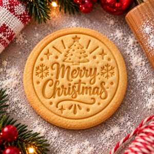 May include: A round, light-tan cookie featuring an embossed design of a Christmas tree, snowflakes, and the text Merry Christmas in a cursive script. The cookie is centered with decorative star and dot accents surrounding the central text.