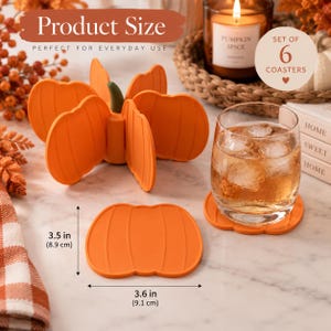 May include: A set of six orange pumpkin-shaped silicone coasters. The coasters measure 8.9 cm by 9.1 cm. One coaster is placed flat, while the others are stacked in a vertical pumpkin-shaped holder with a green stem top.