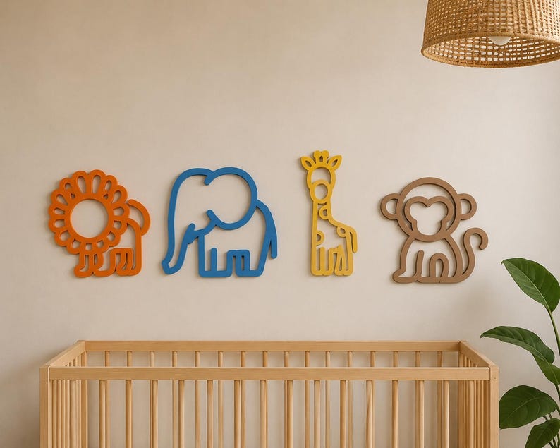 May include: Four colorful wooden animal cutouts: a lion, elephant, giraffe, and monkey. The lion is orange, the elephant is blue, the giraffe is yellow, and the monkey is brown. They are mounted on a light-colored wall above a wooden crib.