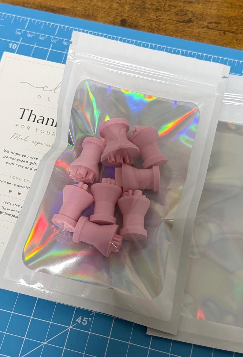 Pink personalized cookie stamps packed in a pouch with the Clair Design thank-you card