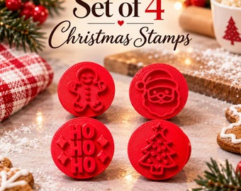 Puede incluir: Un juego de cuatro sellos circulares rojos con diseños navideños en relieve que incluyen un hombre de jengibre, una cara de Papá Noel, el texto HO HO HO con estrellas y un árbol de Navidad decorado con una estrella.