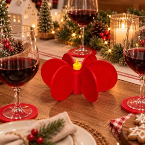 May include: A bright red, multi-piece circular coaster set that assembles into a three-dimensional flower-like shape. The individual red circular coasters feature a central yellow connector piece, designed to stack or stand upright when not in use.
