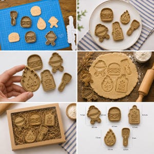 May include: A set of five tan cookie cutters featuring grill-themed shapes including a burger, a grill, a spatula, a flame with the text DAD, and a rectangular sign with the text KING OF THE GRILL. The set includes measurements in centimeters.
