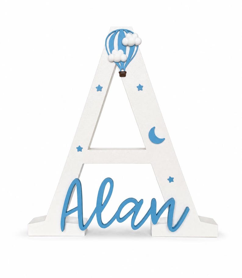 May include: A white wooden letter "A" with blue accents. The letter is decorated with a blue hot air balloon, clouds, stars, and a crescent moon. The name "Alan" is written in blue script across the base.