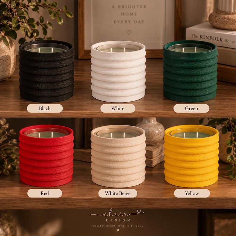 Puede incluir: Seis velas cil&iacute;ndricas en recipientes acanalados, dispuestas en dos filas. Los colores son negro, blanco, verde, rojo, blanco beige y amarillo. Cada vela presenta un inserto de vidrio transparente con dos mechas visibles en el recipiente.