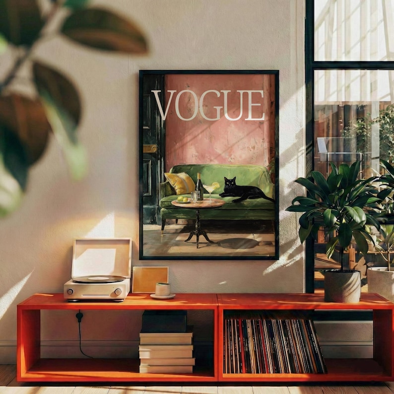 Puede incluir: Una impresi&oacute;n art&iacute;stica enmarcada de "VOGUE" representa un sof&aacute; verde con un gato negro, una mesa con una bebida y una botella. Un tocadiscos se encuentra en una consola multimedia rojo-naranja con discos de vinilo y libros. Una planta est&aacute; en el fondo.