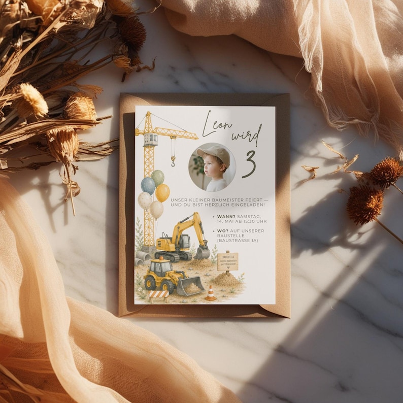 May include: A birthday invitation featuring a watercolor illustration of construction vehicles, a crane, and balloons. The invitation includes the text "Leon wird 3" and event details. The invitation is set on a brown envelope.