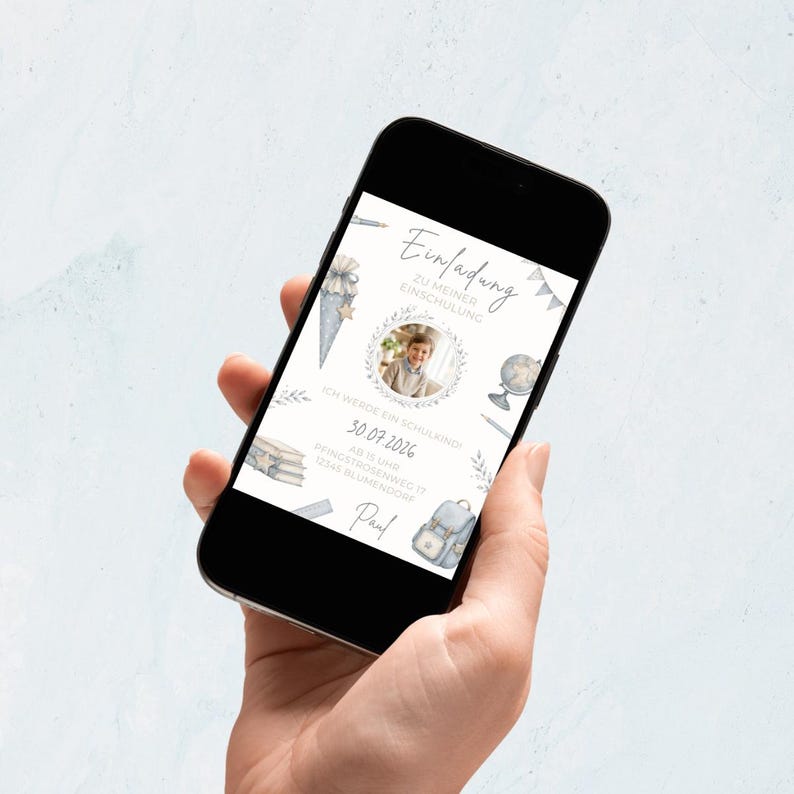 Pu&ograve; includere: Uno smartphone mostra un invito digitale per il primo giorno di scuola di un bambino. L'invito presenta illustrazioni ad acquerello di materiale scolastico, una foto e il testo "Einladung zu meiner Einschulung" e la data.