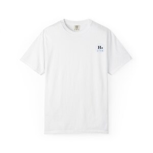 Peut inclure: T-shirt blanc uni avec un petit motif bleu et blanc sur le côté droit de la poitrine. Le motif comprend les lettres "Ho" et les chiffres "p 0,05". Le t-shirt a un col rond et des manches courtes. Le tissu semble doux.