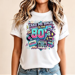 May include: White t-shirt with a colorful graphic design featuring the text "TAKE ME BACK TO THE 80's". The design includes a record, cassette tapes, a boombox, and an arcade game, all in vibrant colors.