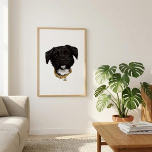 Puede incluir: Retrato enmarcado de un perro negro con una mancha blanca en el pecho y un collar amarillo. El pelaje del perro es detallado y el retrato está sobre un fondo blanco. El marco es de madera clara.