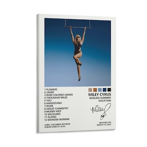 May include: A framed poster featuring Miley Cyrus's "Endless Summer Vacation" album art. The image shows Cyrus hanging from a bar against a blue sky. The poster includes the album's tracklist, the artist's signature, and release date.