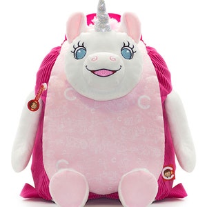 Op de afbeelding: Een roze en witte pluche unicorn rugzak met een glinsterend hoorn en een glimlachend gezicht. De rugzak heeft een roze corduroy klep met een klein aapje logo.