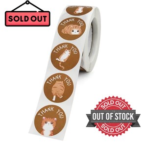 Puede incluir: Un rollo de pegatinas marrones y blancas con ilustraciones de gatos de dibujos animados. Cada pegatina tiene las palabras "THANK YOU" en un dise&ntilde;o circular. La imagen tambi&eacute;n incluye un letrero de "SOLD OUT" y una insignia de "OUT OF STOCK".