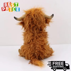Puede incluir: Un peluche de vaca de las Tierras Altas, visto desde atr&aacute;s, con pelo largo y lanudo de color marr&oacute;n rojizo. Tiene cuernos peque&ntilde;os y curvados y una cola esponjosa. El juguete est&aacute; sobre una superficie blanca. El texto "BEST PRICE" es visible.