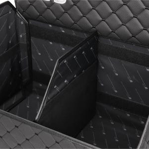 K&ouml;nnte beinhalten: Schwarzer Kofferraum-Organizer mit mehreren F&auml;chern. Die Au&szlig;enseite hat ein Steppmuster, w&auml;hrend die Innenseite ein bedrucktes Design aufweist. Der Organizer verf&uuml;gt &uuml;ber Klettverschl&uuml;sse f&uuml;r sichere Aufbewahrung.