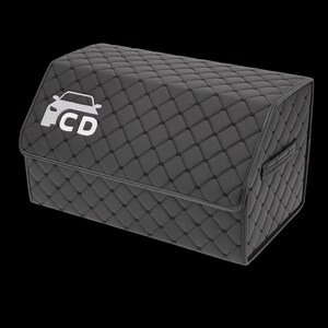 May include: A dark gray, quilted car trunk organizer with a white car logo and the letters "CD" on the front. The organizer has a handle on the side and a diamond pattern.