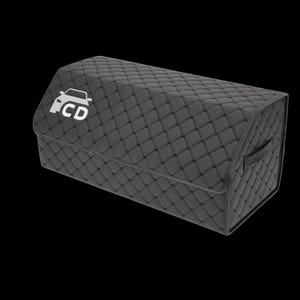 May include: A dark gray, quilted car trunk organizer with a rectangular shape. The organizer features a white car logo with the letters "CD" on the front flap and a handle on the side. The stitching creates a diamond pattern.