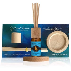 May include: A reed diffuser kit featuring a small amber glass bottle with a wooden cap and eight reeds. The product label reads Eternal Essence Bali Mango type. The set includes a round wooden tray and a blue display card with the text Eternal Essence Premium Fragrance Oils and barnhouse blue Reed Diffuser. The kit contains 1 tray, 1 wooden cap, and 8 reeds.