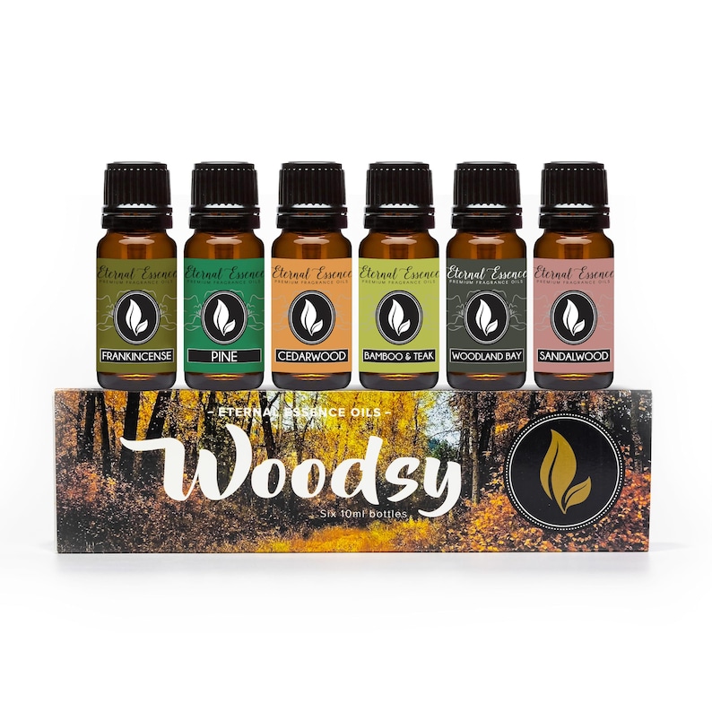 Puede incluir: Seis frascos de vidrio &aacute;mbar con tapas negras, cada uno con 10ml de aceite arom&aacute;tico Eternal Essence. Las etiquetas dicen Frankincense, Pine, Cedarwood, Bamboo & Teak, Woodland Bay y Sandalwood. Est&aacute;n sobre una caja con la etiqueta Woodsy.