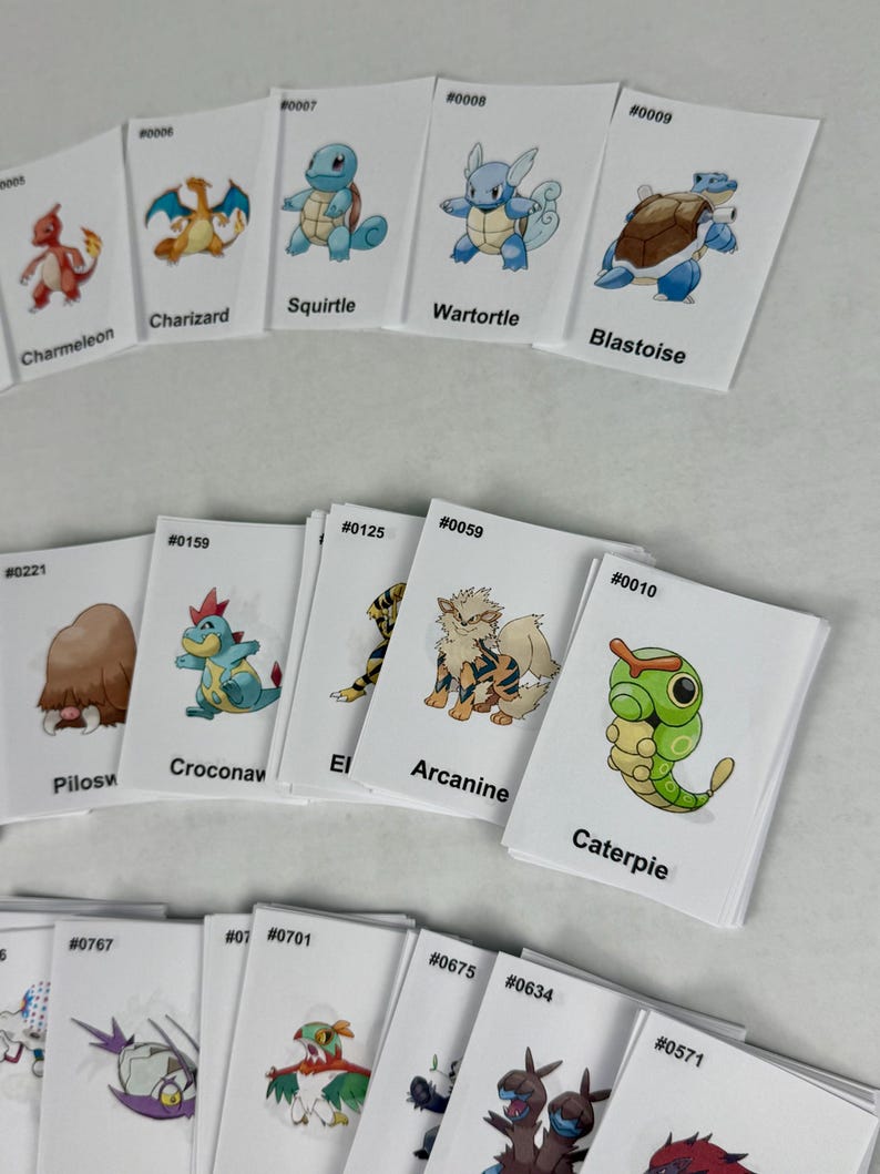 May include: A collection of rectangular white cards featuring colorful illustrations of various creatures. Each card displays a unique character, a corresponding identification number, and a name printed in black text, such as Charmeleon, Charizard, Squirtle, Wartortle, Blastoise, Piloswine, Croconaw, Arcanine, and Caterpie.