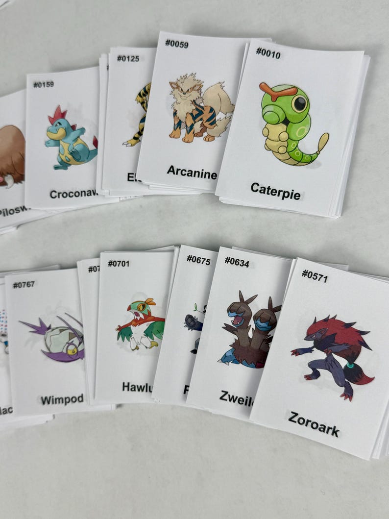 May include: A collection of white rectangular trading cards featuring colorful illustrations of various creatures. Each card displays a unique character, a corresponding identification number, and a name printed in black text at the bottom.