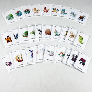 May include: A collection of white rectangular trading cards featuring various colorful cartoon creature illustrations. Each card displays a unique character, a corresponding identification number, and a name printed in black text below the image.