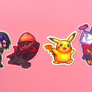 Op de afbeelding: Vier kleurrijke stickers op een roze achtergrond. De stickers tonen stripfiguren: een meisje met paars haar, een man met een oranje helm, een gele Pikachu en een tv-hoofdfiguur in een rood pak.