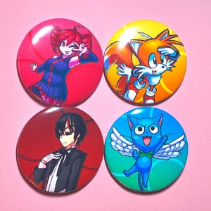 May include: Four round buttons with colorful anime-style character illustrations. The buttons feature characters with red, orange, and blue color schemes. The background is a light pink.