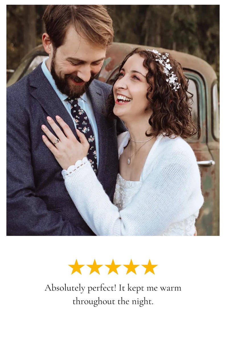 Puede incluir: Una pareja se sonr&iacute;e, la mujer lleva una estola de punto blanco sobre su vestido de novia. La estola tiene un delicado encaje. La pareja est&aacute; de pie frente a un cami&oacute;n vintage.