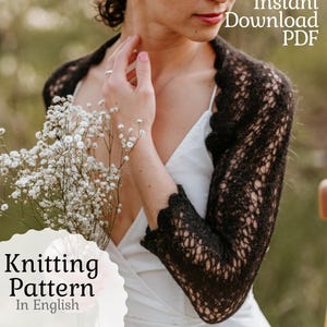 May include: A black lace shrug with scalloped edges is featured in this image. The words "Instant Download PDF" are visible. The words "Knitting Pattern In English" are also visible. The shrug is worn over a white dress.